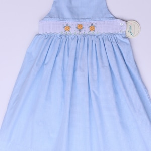 Hand embroidered girls smocked dress. Light blue and white smock sleeveless dress and hand embroidered turtles.