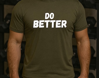 May include: Olive green crew neck t-shirt with the white text "DO BETTER" across the chest. The shirt is made of a soft material and has short sleeves. The background includes gym equipment.