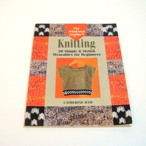 May include: A book titled "Knitting: 20 Simple & Stylish Wearables for Beginners" by Catherine Ham. The book cover features a colorful knitted sweater and various knitting patterns.