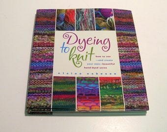 May include: A square book titled "Dyeing to Knit" by Elaine Eskesen. The cover features colorful yarn samples and the text "how to use - and create your own-beautiful hand-dyed yarns". The book's design incorporates various shades of yarn.