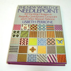 May include: The New World of Needlepoint book cover features a colorful display of 101 needlepoint designs in bargello, quickpoint, grospoint, and other repeat patterns. The book cover is gray with a purple spine.