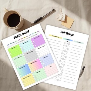 Op de afbeelding: Twee witte papieren planners met de titels "Brain Dump" en "Task Triage" liggen op een beige oppervlak. De "Brain Dump" planner heeft kleurrijke vakken voor notities. Een kopje koffie, een pen en plaknotities zijn ook aanwezig.