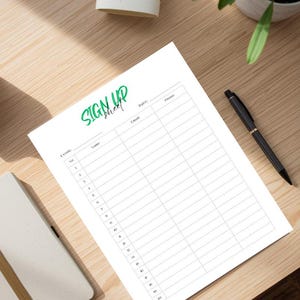 Puede incluir: Una hoja de inscripción blanca con las palabras "SIGN UP sheet" en verde. La hoja tiene líneas numeradas para los detalles del evento, nombres, correo electrónico, fecha y teléfono. Un bolígrafo negro descansa sobre la superficie de madera.