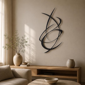 Op de afbeelding: Een zwarte metalen wandsculptuur met een reeks elkaar kruisende, gebogen lijnen die een abstracte, langwerpige vorm vormen. Het object is samengesteld uit dunne, gladde, donkergekleurde metalen strips die een dynamisch ontwerp creëren.