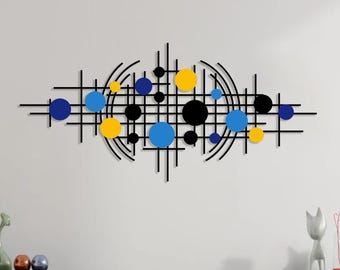 May include: Black metal wall art with a geometric design featuring intersecting lines and circles in shades of blue and yellow.