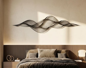 May include: A dark-colored, elongated wall sculpture featuring a series of interconnected, flowing, wave-like lines that create a rhythmic, layered pattern. The piece is mounted horizontally, displaying a complex, open-work design of curved metal.