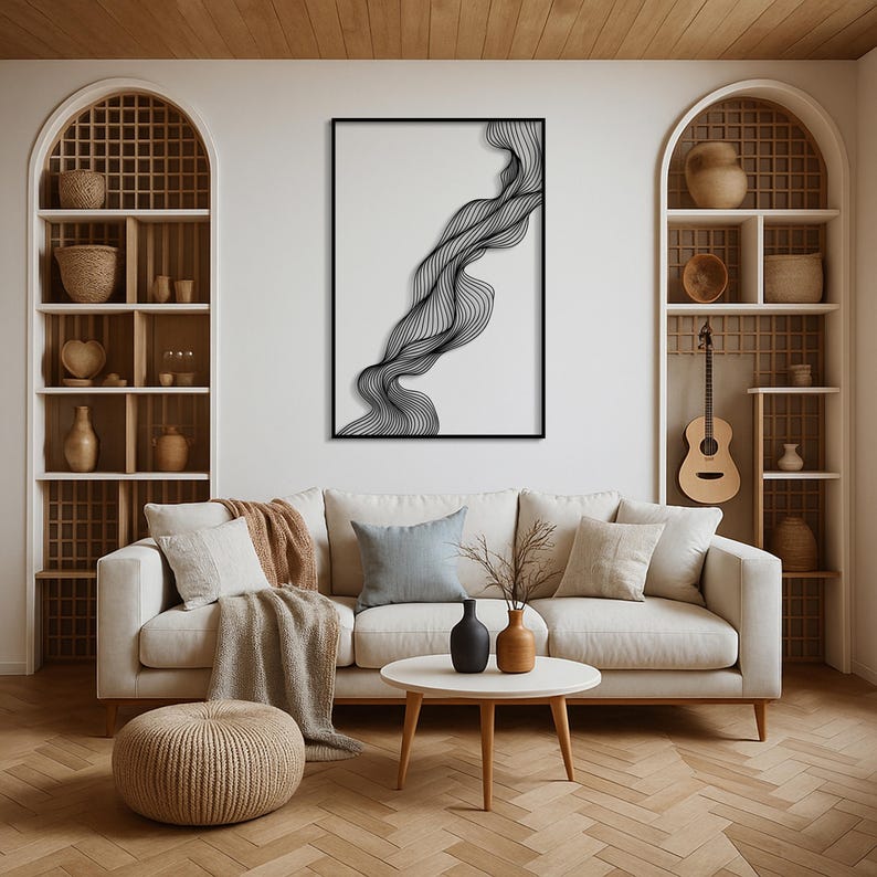 May include: A modern living room with a white sofa, a round coffee table, and a large abstract black and white wall art. The room features wooden shelves, a guitar, and a woven ottoman. Decorative vases and pillows add to the decor.
