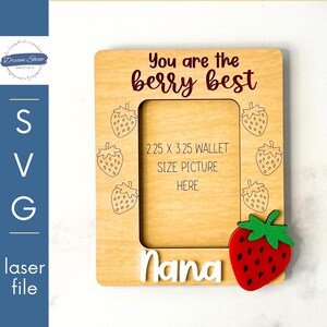 Op de afbeelding: Een houten fotolijst met een aardbeidesontwerp en de tekst "You are the berry best Nana". De lijst is ontworpen om een ​​foto van 2,25 x 3,25 inch in portefeuilleformaat te bevatten.