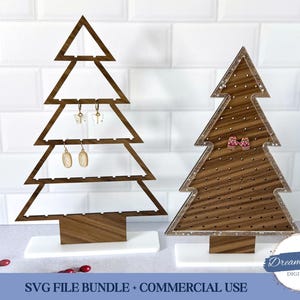 Könnte beinhalten: Zwei ohrringhalter in Form eines Weihnachtsbaums aus Holz mit weißen Sockeln. Einer ist offen und zeigt Ohrringe, der andere ist massiv mit kleinen Löchern. Der Text "SVG FILE BUNDLE + COMMERCIAL USE" befindet sich unten.