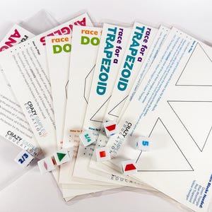 May include: A collection of educational games, including "Race for Triangles" and "Race for a Trapezoid." The games feature printed instructions and geometric shapes. Dice and shape blocks are included. The game cards are in clear plastic sleeves.