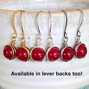 May include: Six pairs of earrings with red, round beads. The earrings are available in gold and silver tones. The text "Available in lever backs too!" is at the bottom of the image.