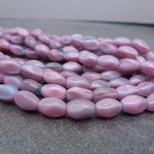 May include: A set of three ceramic mugs with a speckled, cream-colored glaze. Each mug features a different hand-painted floral design in shades of blue, green, and yellow. The mugs have a simple, modern shape.