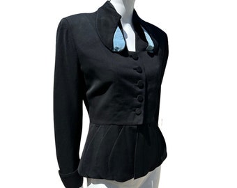 Könnte beinhalten: Ein schwarzer Blazer mit tailliertem Schnitt und einem blauen Satin-Kragen. Der Blazer hat einen Knopfverschluss und lange Ärmel.