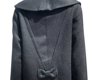 May include: A black wool jacket with a large collar and a bow detail on the back.