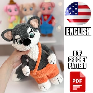 May include: A plush crochet wolf toy featuring dark gray and white yarn, large green eyes, a black nose, and orange overalls with a matching orange strap. The text reads ENGLISH, PDF CROCHET PATTERN, and PDF, accompanied by a US flag icon.