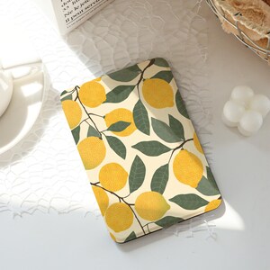 May include: A rectangular tray with a lemon pattern. The tray has a cream-coloured background with yellow lemons and green leaves. The lemons are arranged on branches, creating a bright and summery design. The tray is likely used for serving or decorative purposes.