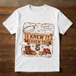 May include: A white short-sleeve t-shirt featuring a graphic print with a scroll banner that reads I KNEW IT, I KNEW YOU, the number 5, a red cowboy hat, brown cowboy boots, alphabet blocks, a beaded necklace, and the text infinity and beyond.