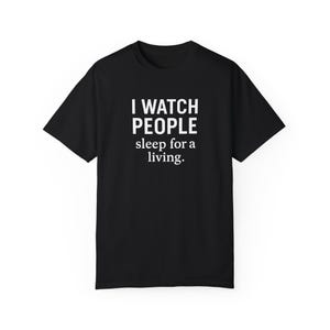 Könnte beinhalten: Schwarzes T-Shirt mit weißem Text, der "I WATCH PEOPLE sleep for a living." lautet.