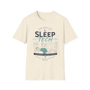 Peut inclure: T-shirt crème avec un motif graphique. Le motif présente les mots "SLEEP TECH" au-dessus d'une illustration d'un technicien du sommeil surveillant un patient. Le texte supplémentaire comprend "MORE THAN A JOB" et "EVERY WAVEFORM - EVERY PATIENT - EVERY NIGHT."