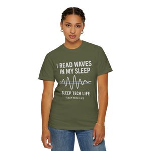 May include: A green t-shirt with the text "I read waves in my sleep" and a graphic of a brain wave. The text "Sleep Tech Life" is also printed on the shirt.