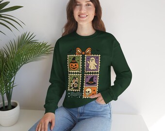 Può includere: Felpa verde scuro con un design a tema Halloween. Il design include quattro quadrati a forma di francobollo con una zucca, un fantasma, una casa infestata, un cappello da strega e un teschio. Girocollo e maniche lunghe.