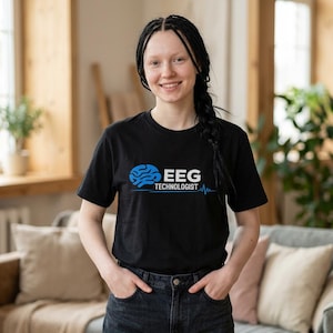 Könnte beinhalten: Ein schwarzes Kurzarm-T-Shirt mit einer blauen Grafik eines menschlichen Gehirns auf der linken Seite, gefolgt von dem weißen Text EEG TECHNOLOGIST und einer dünnen blauen Linie darunter, die einem EKG-Wellenmuster ähnelt.