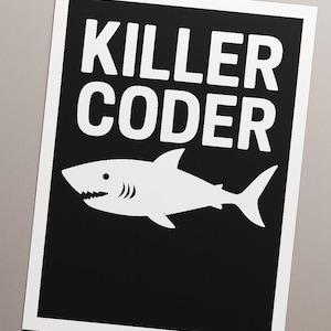 Könnte beinhalten: Ein schwarz-weißes Poster mit dem Text "KILLER CODER" in fetten weißen Buchstaben über einer weißen Hai-Illustration. Der Hai hat ein gezacktes Maul und blickt nach links.