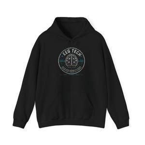 Op de afbeelding: Zwarte hoodie met een cirkelvormige afbeelding op de voorkant. De afbeelding bevat de tekst "EEG TECH" en een hersenillustratie. Daaronder staat de tekst "BEING EVERY READING IS A PERSON..." in kleinere letters.