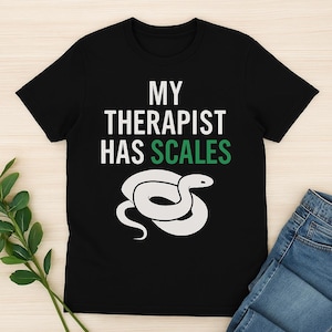 Pode incluir: Camiseta preta com texto branco que diz "My Therapist Has Scales" e um gráfico de cobra verde.