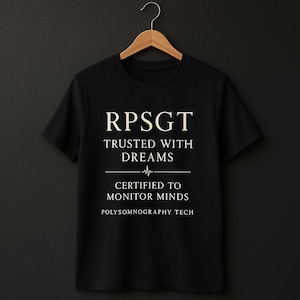 May include: Black t-shirt with white text that reads "RPSGT Trusted with Dreams Certified to Monitor Minds Polysomnography Tech".