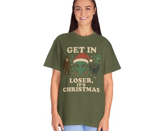 Op de afbeelding: Olijfgroen t-shirt met de tekst "GET IN LOSER, IT'S CHRISTMAS". De afbeelding bevat een alien met een kerstmuts, een UFO, een vleermuisachtig wezen en een Bigfoot. Een casual, unisex stijl.