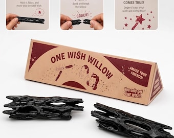 May include: A triangular cardboard box labeled One Wish Willow with two black, textured, hollow willow-like objects. The box features instructions: 1. Make a wish, 2. Break it, 3. Your wish comes true, along with illustrations of a person and a star wand.