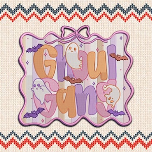 Peut inclure: Écusson brodé avec les mots "Ghoul Gang" en orange et violet, avec des motifs de fantômes et de chauves-souris. L'écusson a une bordure rose festonnée et un nœud en haut. Le fond est un tissu en tricot crème.