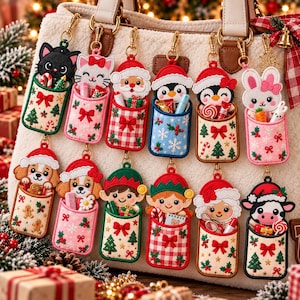 May include: A collection of twelve silicone keychain pouches, each featuring a different holiday character like Santa, elves, penguins, and animals, attached to a white fuzzy bag. Each pouch has a festive pattern and holds small items.