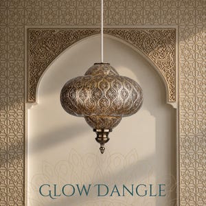 May include: A metallic pendant lamp with an intricate, perforated pattern and a rounded, bulbous shape. The fixture features a pointed finial at the bottom and is suspended by a white cord. The text GLOW DANGLE is printed at the bottom.
