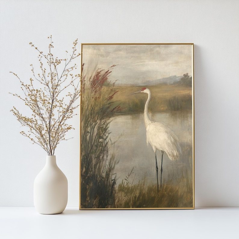 May include: A vintage painting depicting a white crane standing in a marsh, with reeds and a pond in the background. The crane has a red head and a long neck. The painting is rendered in muted tones of brown, green, and grey.
