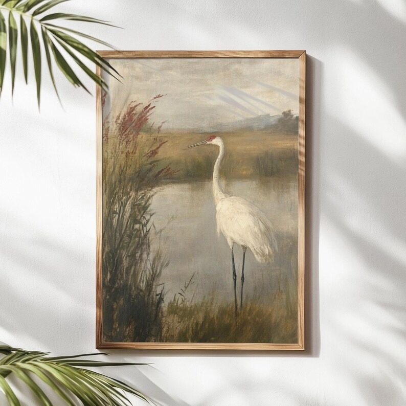 May include: A vintage painting depicting a white crane standing in a marsh with tall reeds. The crane has a long neck and long legs. The background is a soft, muted green and brown.
