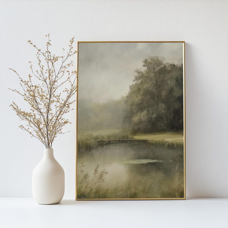 K&ouml;nnte beinhalten: Ein gerahmtes Gem&auml;lde einer nebeligen Landschaft mit einer kleinen Holzbr&uuml;cke &uuml;ber einem Teich. Das Gem&auml;lde ist in Gr&uuml;nt&ouml;nen und Braunt&ouml;nen gehalten, mit einem Hauch von Blau im Wasser.