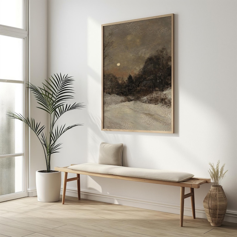 May include: A wooden bench with a white cushion sits in a room with a large window and a framed painting of a snowy landscape with a full moon.