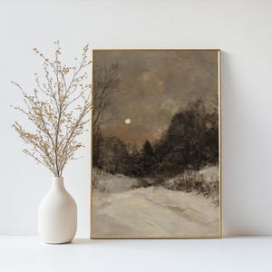 May include: A framed painting of a snowy landscape with a full moon in the sky. The painting is in shades of gray and brown, with a hint of orange in the sky.