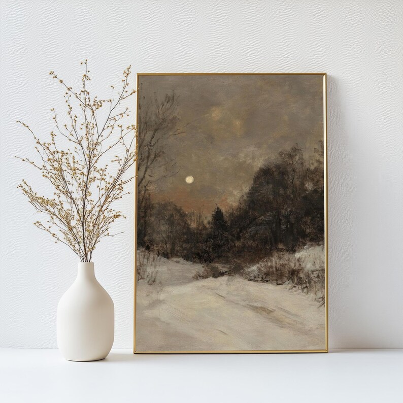May include: A framed painting of a snowy landscape with a full moon in the sky. The painting is in shades of gray and brown, with a hint of orange in the sky.