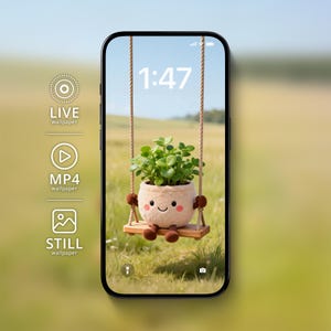 Może przedstawiać: Smartfon wyświetla kapryśną tapetę z rośliną doniczkową na huśtawce. Roślina ma uśmiechniętą twarz i jest zawieszona na linie na tle pola i błękitnego nieba. Wyświetlana jest godzina 1:47.