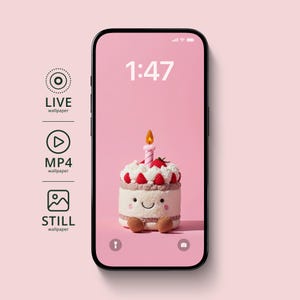 May include: A smartphone displays a pink screen with a cake-shaped wallpaper. The cake has a lit candle, strawberries, and a smiling face. The time 1:47 is shown on the screen. Icons for live, MP4, and still wallpapers are on the left.