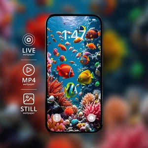 Może przedstawiać: Smartfon wyświetlający podwodną rafę koralową z kolorowymi rybami tropikalnymi w odcieniach pomarańczu, żółci i błękitu. Na ekranie widoczna jest godzina 1:47 oraz ikony LIVE wallpaper, MP4 wallpaper i STILL wallpaper po lewej stronie ekranu.