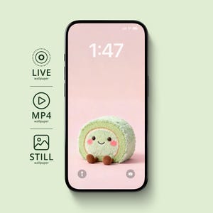 May include: A smartphone displays a cute, smiling, green roll cake wallpaper against a pink background. The time 1:47 is shown in white. The phone is black with a green background.