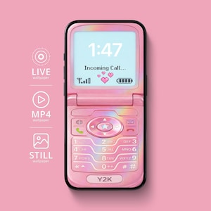 May include: A pink Y2K flip phone with a black border. The screen displays "1:47" and "Incoming Call..." with pixelated hearts. The phone has a keypad with numbers and symbols, and the text "Y2K" is at the bottom.