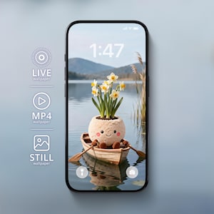 以下が含まれることがあります： スマートフォン画面には、気まぐれな壁紙が表示されています。小さなボートに乗った笑顔のぬいぐるみキャラクターがオールを持ち、水仙の植木鉢を持っています。背景には湖と山が表示されています。時刻1:47が上部に表示されています。