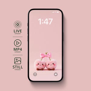 May include: A smartphone displays a pink wallpaper featuring two plush, smiling cherries tied together with a pink bow. The time 1:47 is shown at the top. The phone is surrounded by icons for live, MP4, and still wallpapers.