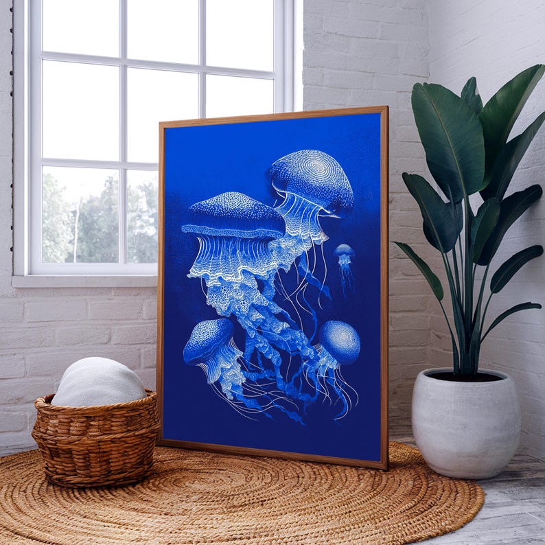 May include: A framed art print featuring a detailed illustration of several jellyfish in shades of blue and white against a deep blue background. The artwork is displayed in a room with a window and a potted plant.