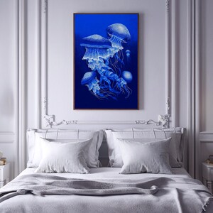 May include: A framed art print featuring a detailed illustration of several blue jellyfish against a deep blue background. The jellyfish have intricate white detailing, creating a striking contrast. The artwork is displayed above a bed with white pillows and a gray blanket.